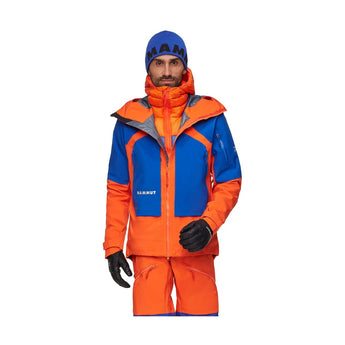 Man wearing Mammut Eiger Nordwand Pro HS hooded jacket in orange and royal blue