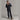Man adjusting black quilted jacket collar standing pose