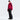 Full body front view woman in burgundy red color-block ski suit helmet and boots