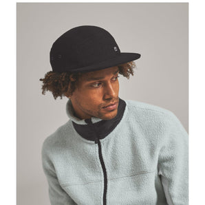 Woman wearing black wool five-panel cap with fleece jacket